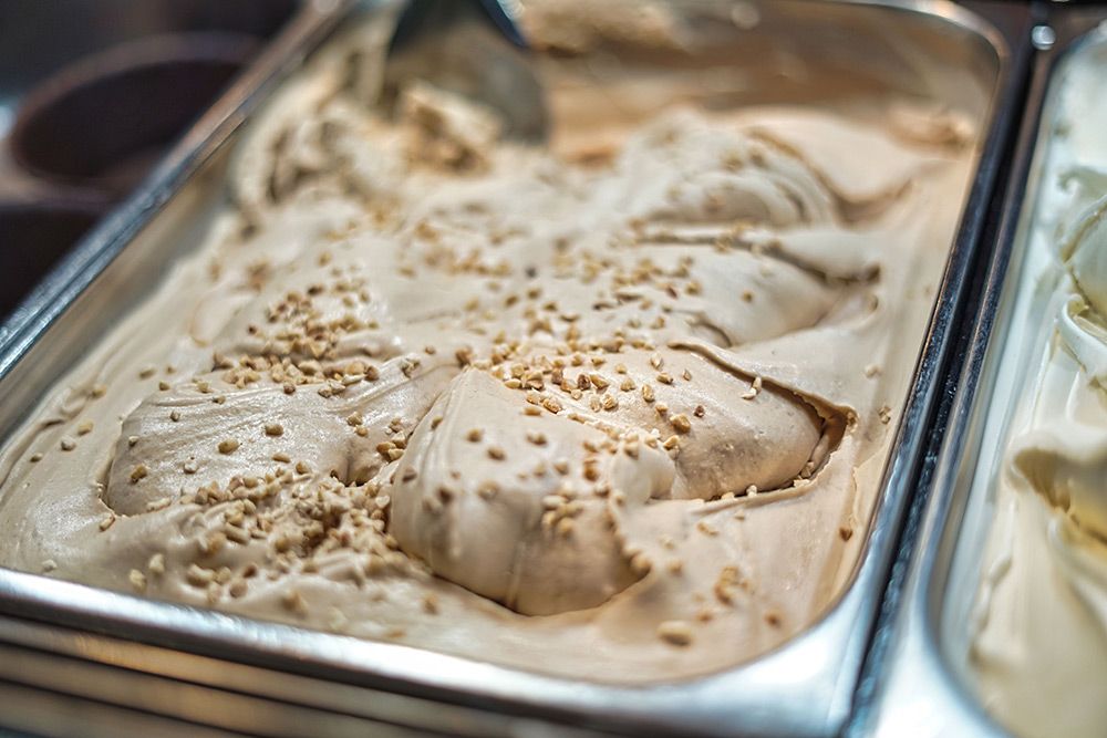 Artisan pistachio and chocolate gelato with balanced scoop texture in a stainless steel pan